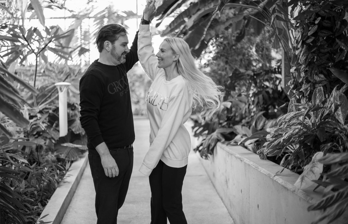 Kendra and Trevor dancing together in a botanical garden